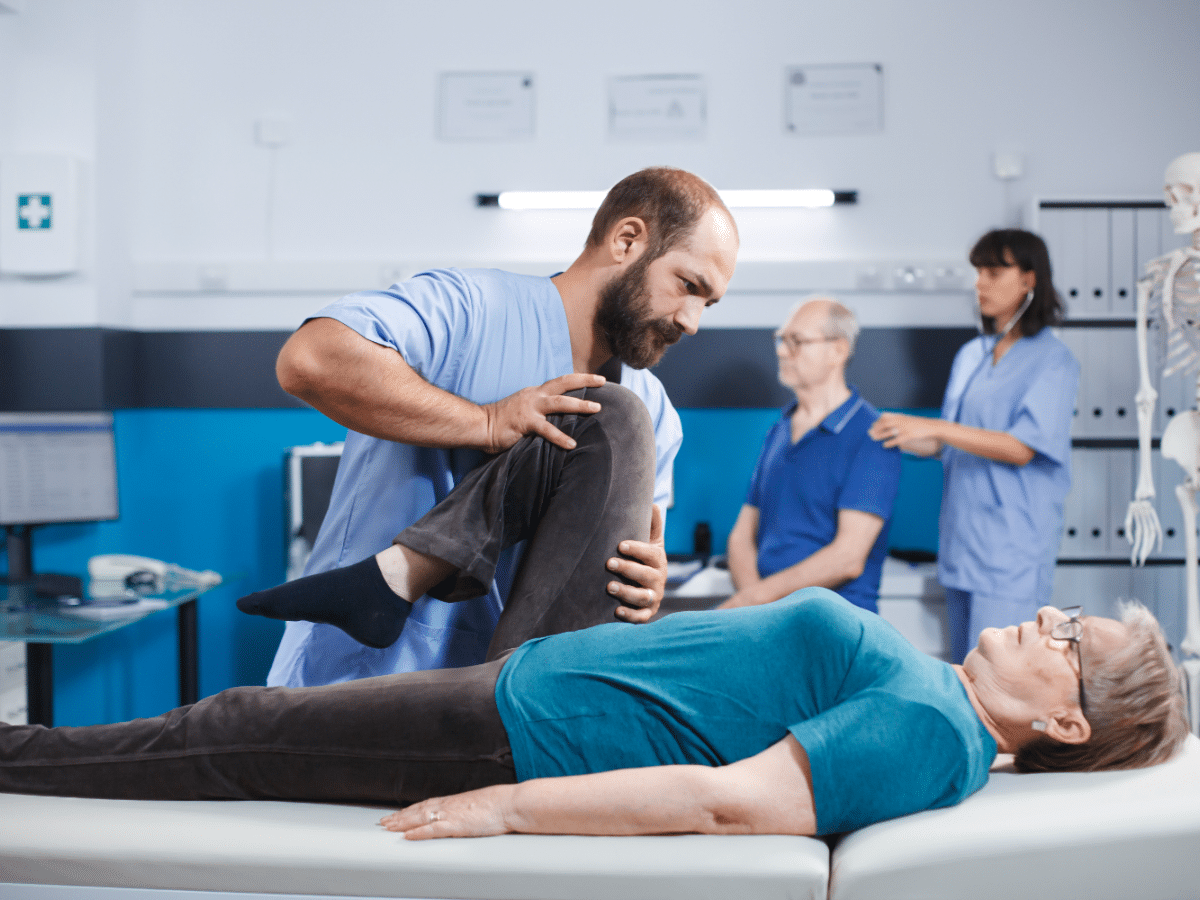A therapist guides his patient through leg exercises to promote quicker recovery.